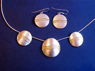 Necklace with three circular pendants with a horizontal wave striation and matching earings