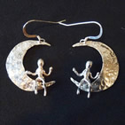 Earrings: crescent moon with small seated figure