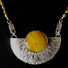 Pendant: circular amber sun in inverted semi-circular silver setting with radiating striations