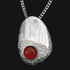 Silver bean-shaped pendant with small round red glass bead inset